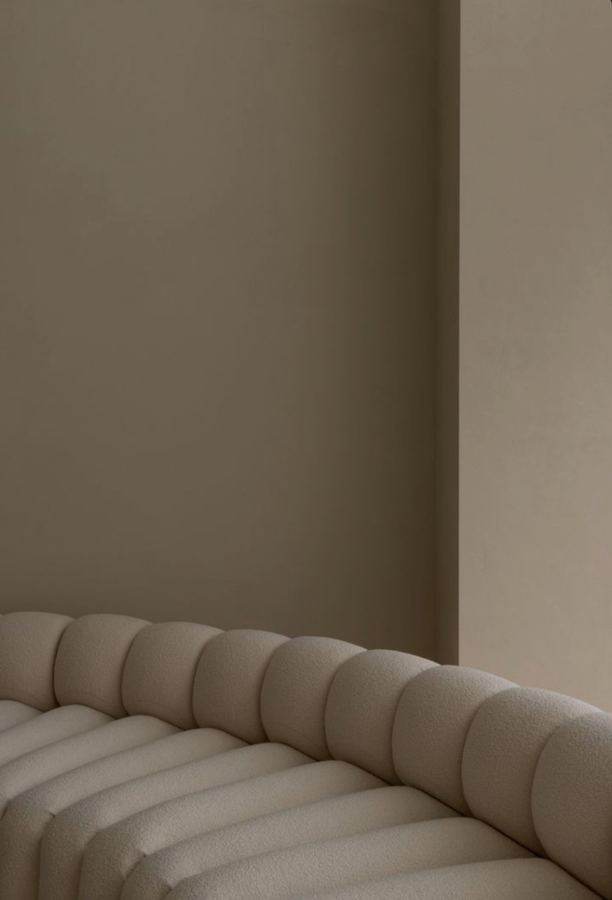 Channel-tufted seating against plaster